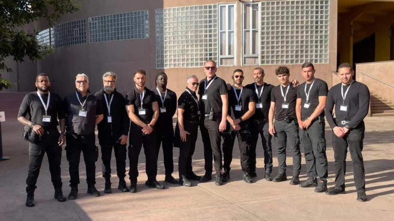 Squadra di addetti alla sicurezza in abito scuro con badge, in posa all'aperto