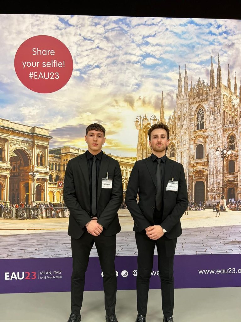 Addetti security davanti a una parete fotografica con il duomo di milano