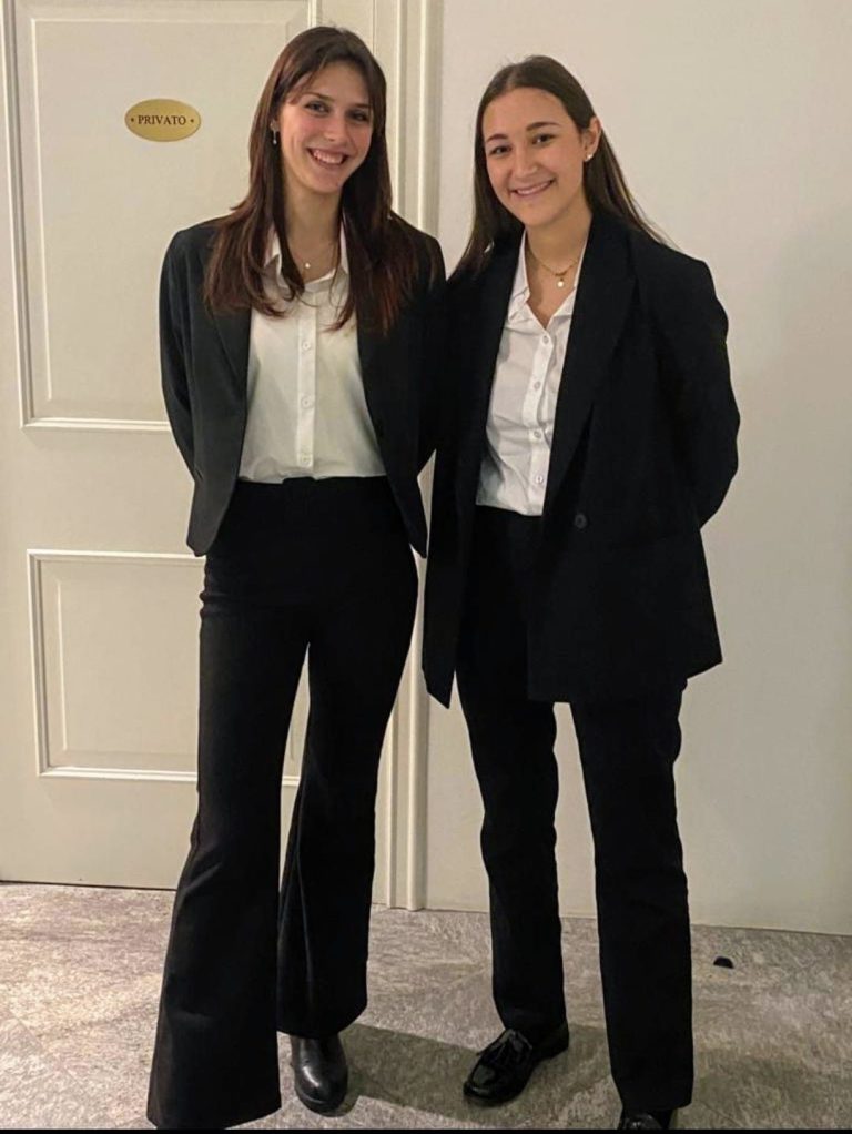 Hostess in tailleur scuro all'accoglienza di un evento